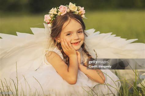 Angel with white wings on green grass